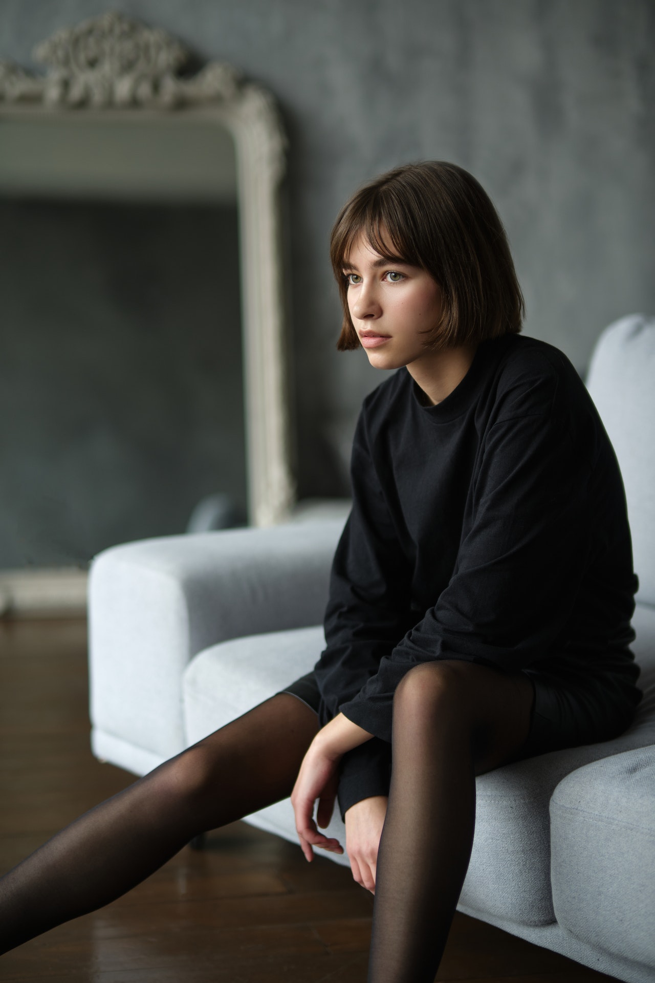 kobieta w czarnej bluzce siedzi na sofie